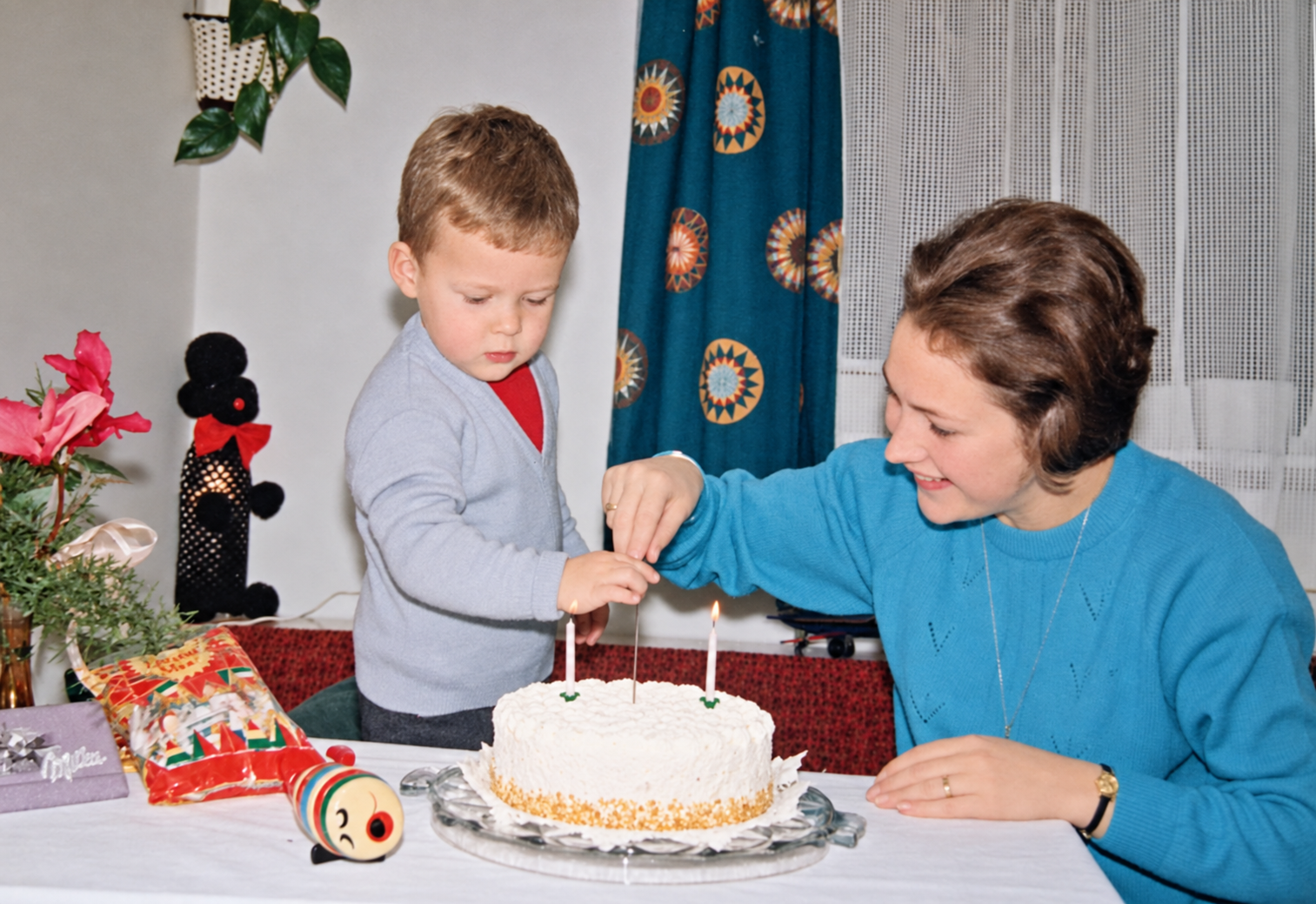 Gerti mit einem Kind an einem Tisch mit Geburtstagstorte